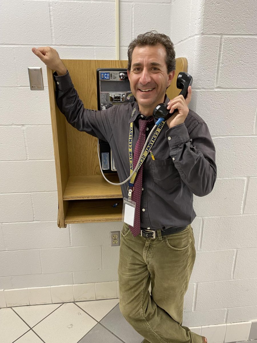 Mr. Adams at a payphone that "doesn't work"